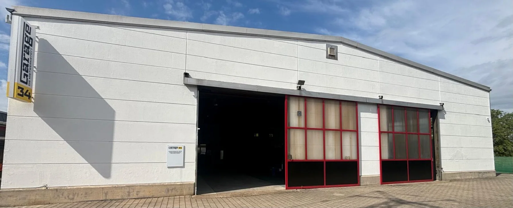 Einfahrt der Mietwerkstatt Garage 34 bei Heidelberg mit geöffnetem Hallentor